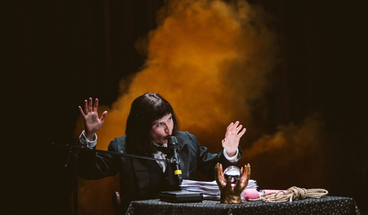 Scena dello spettacolo The brotherhood: Carolina Bianchi a un tavolino con sfera di cristallo