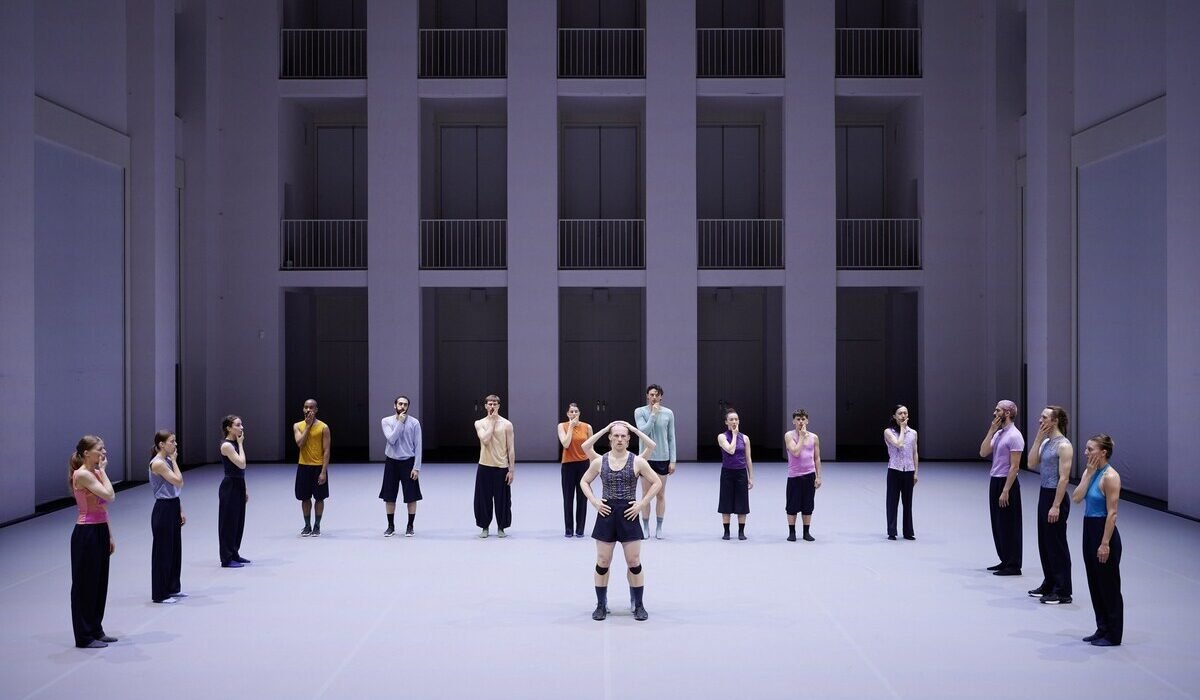 Gruppo di danzatori della Dresden Frankfurt Dance Company nella pièce Undertainment del coreografo William Forsythe, in semicerchio sul palco