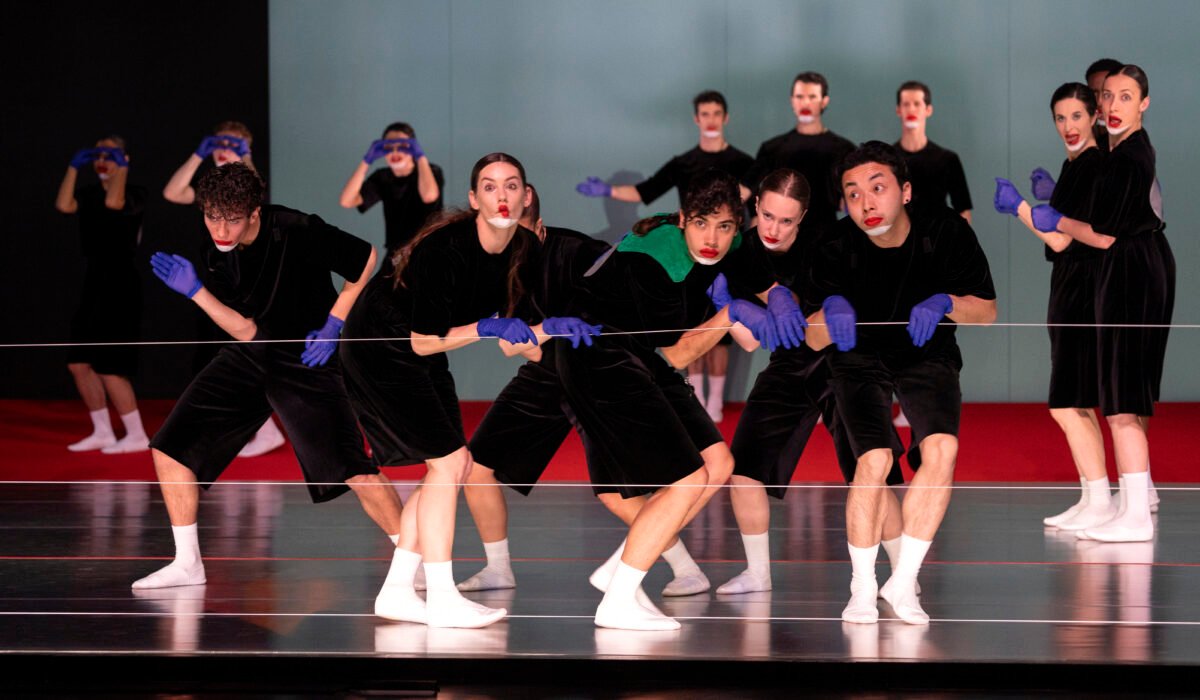 Danzatori in costumi neri e guanti di lattice viola in una coreografia di Marlene Monteiro Freitas