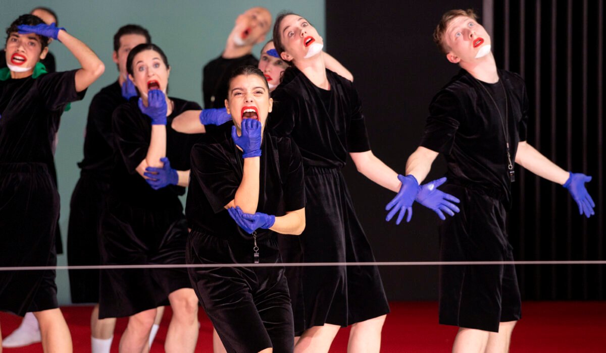 Danzatori in costumi neri e guanti di lattice viola in una coreografia di Marlene Monteiro Freitas