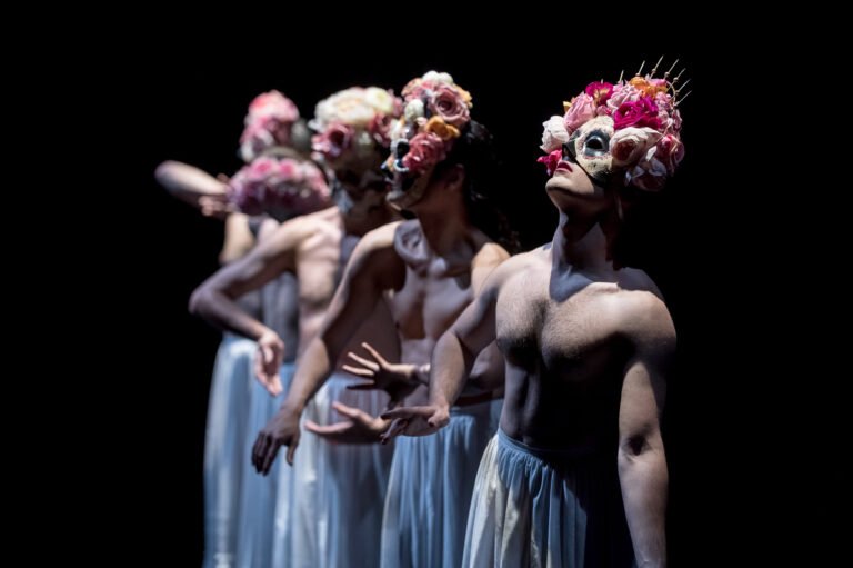 Danseurs avec masques peintes et coiffures avec fleurs